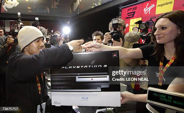 London, UNITED KINGDOM: Ritasu Thomas, aged 17, buys his Playstation 3 in the Virgin Megastore, London on the day that Sony launches its PlayStation...