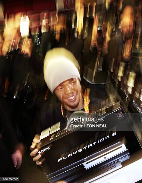 London, UNITED KINGDOM: Ritasu Thomas, aged 17, holds up his Playstation 3 in the Virgin Megastore, London on the day that Sony launches its...
