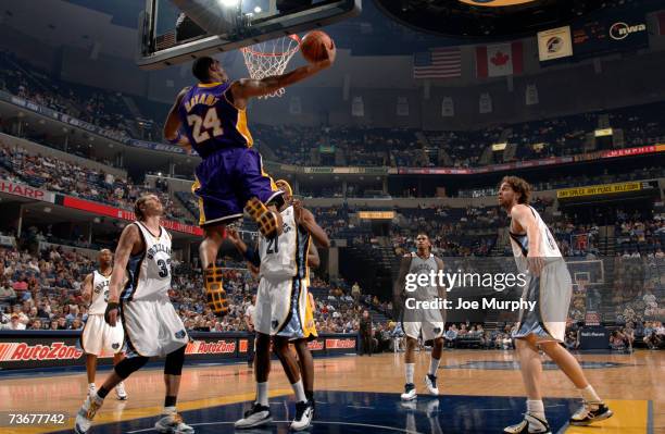 Kobe Bryant of the Los Angeles Lakers shoots a layup past Mike Miller and Hakim Warrick of the Memphis Grizzlies on March 22, 2007 at FedExForum in...