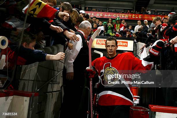 Jason Spezza of the Ottawa Senators walks out towards the ice for warmup carrying a "Tribute to Hockey Moms" Pink Stick before a game against the...