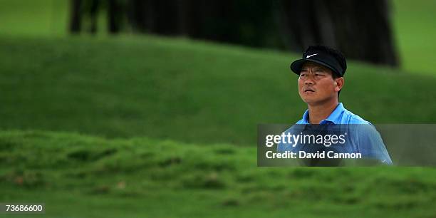 Choi of South Korea peers over the lip of the deep bunker before he plays his third shot at the par 5, 1st hole during the second round of the 2007...