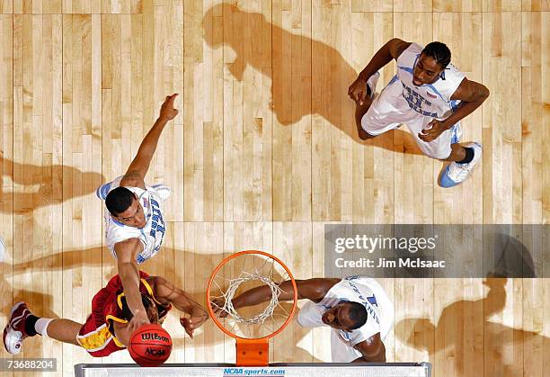 Danny Green of the University of North Carolina Tar Heels blocks the shot off Dwight Lewis of the University of Southern California Trojans during...