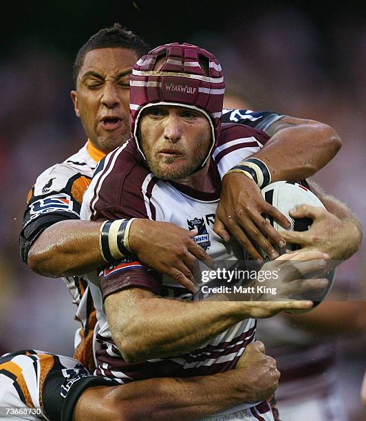 Steve Bell of the Sea Eagles is tackled over the top by Benji Marshall of the Tigers during the round two NRL match between the Wests Tigers and the...