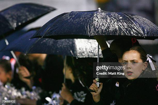 Tigers cheer girls take cover under umbrellas in the rain during the round two NRL match between the Wests Tigers and the Manly Warringah Sea Eagles...