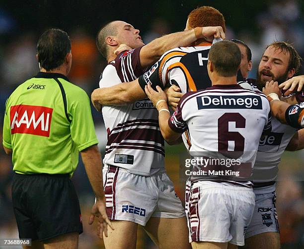 Jason King of the Sea Eagles throws a punch at Keith Galloway of the Tigers during the round two NRL match between the Wests Tigers and the Manly...