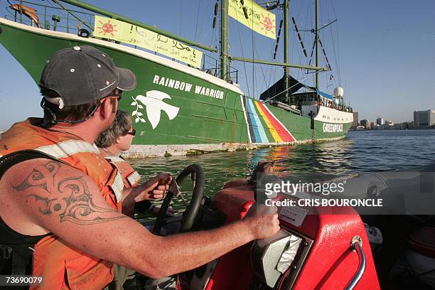 Crew member of Greenpeace's Rainbow Warrior ushers journalists on board for a tour of the ship while anchored in Egypt's Mediterranean port of...