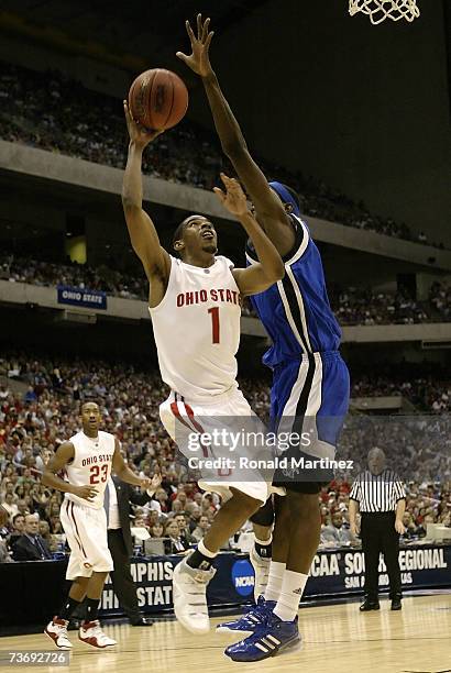 Mike Conley Jr. #1 of the Ohio State Buckeyes drives for a shot attempt against Robert Dozier of the Memphis Tigers during the south regional final...