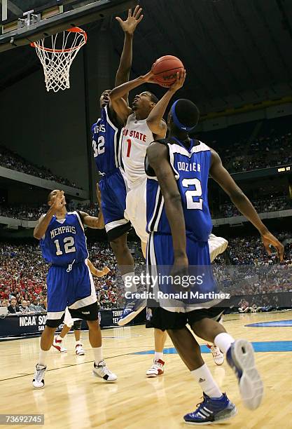 Mike Conley Jr. #1 of the Ohio State Buckeyes drives for a shot attempt against Robert Dozier and Joey Dorsey of the Memphis Tigers during the south...