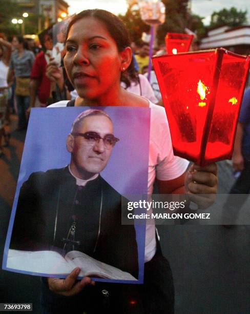 San Salvador, EL SALVADOR: Una feligres salvadorena carga una imagen de monsenor Oscar Arnulfo Romero, durante una peregrinacion en conmemoracion del...