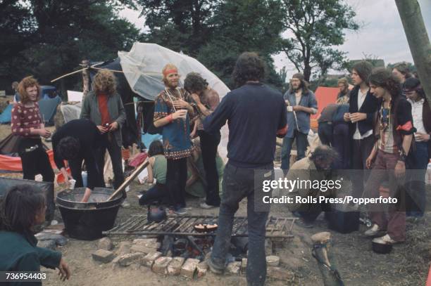 View of rock music fans, festival goers and audience members pictured cooking food over a fire at the Weeley Festival near Clacton in Essex on 28th...