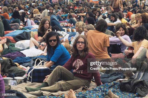 View of rock music fans, festival goers and audience members pictured sitting on blankets in front of the stage at the Weeley Festival near Clacton...