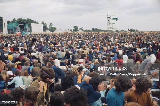 View of rock music fans, festival goers and audience members pictured standing and sitting in front of the stage at the Weeley Festival near Clacton...