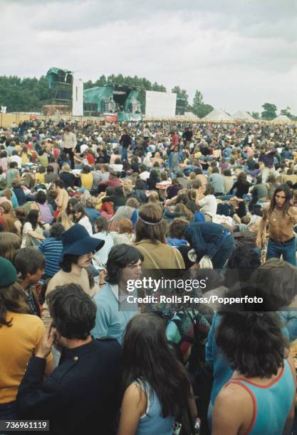 View of rock music fans, festival goers and audience members pictured standing and sitting in front of the stage at the Weeley Festival near Clacton...