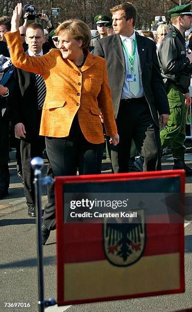 German Chancellor Angela Merkel waves as she leaves Berlin's Brandenburg Gate on the occasion of the 50th anniversary of the signing of the Treaty of...