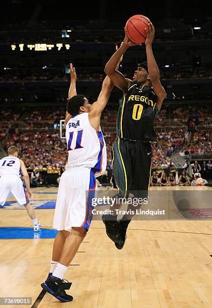 Aaron Brooks of the Oregon Ducks puts up a shot over Taurean Green of the Florida Gators during the midwest regionals of the NCAA Men's Basketball...