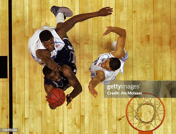 DaJuan Summers of the Georgetown Hoyas goes to the hoop against Deon Thompson and Danny Green of the University of North Carolina Tar Heels in the...