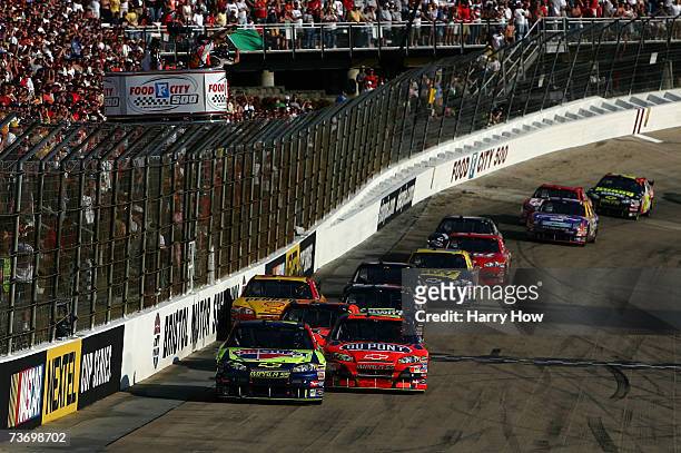 Kyle Busch, driver of the Carquest/Kellogg's Chevrolet, leads Jeff Gordon, driver of the DuPont Chevrolet, at the final restart of the NASCAR Nextel...
