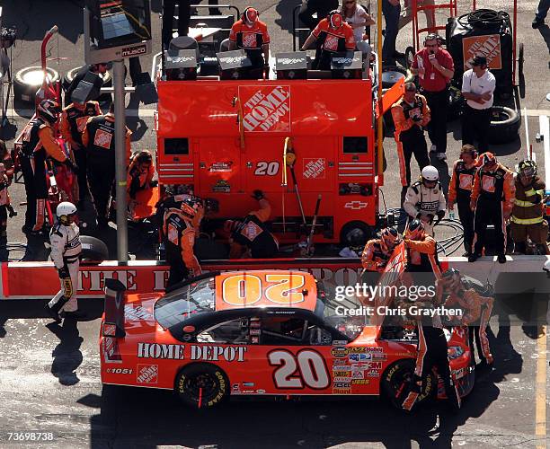 Crew members for Tony Stewart, driver of the The Home Depot Chevrolet, work on the car during a pit stop, during the NASCAR Nextel Cup Series Food...