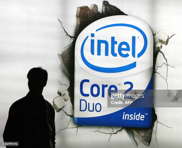 Chinese shopper walks past an advertising billboard of the US chip giant Intel on display at a shopping mall in Beijing, 26 March 2007. US chip giant...