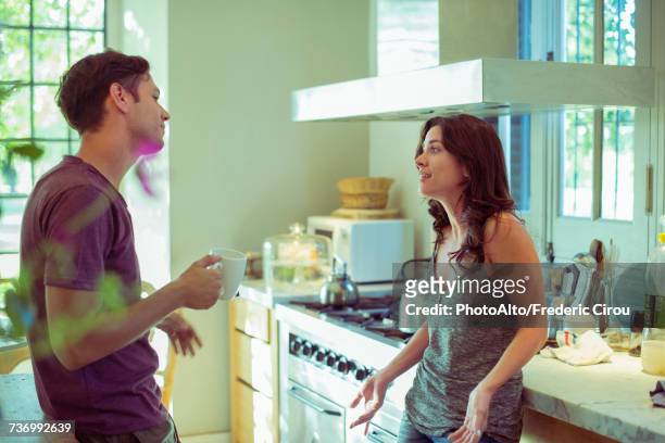 couple talking in kitchen - couple kitchen stockfoto's en -beelden