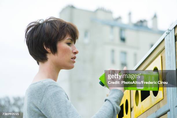 woman placing carton in recycling bin - recycling bins stock pictures, royalty-free photos & images