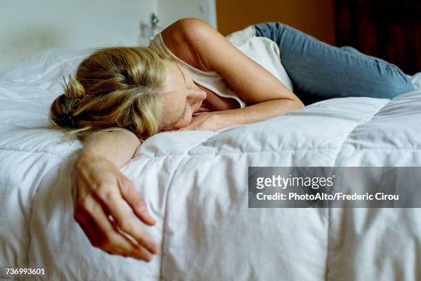 woman lying down on bed - fatigué photos et images de collection