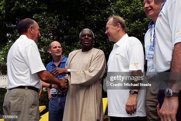 President Lamine Diack, shakes hands with ex athlete Herb Elliott as Lord Mayor Campbell Newman and Premier Peter Beattie look on as the Brisbane...