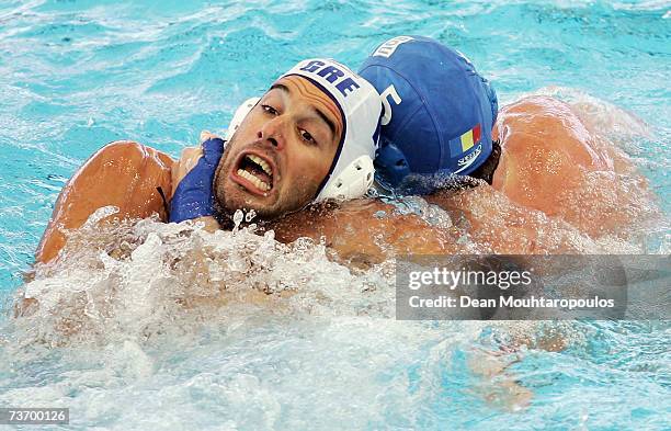 Antonios Vlontakis of Greece is grabbed around the throat by Andrei Iosep of Romania during the Men's Final Round Water Polo match between Greece and...