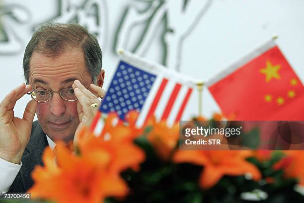Intel President and CEO Paul Otellini adjusts his glasses during a press conference at the Great Hall of the People in Beijing 26 March 2007. US chip...