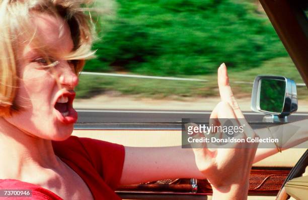 Actress Bridget Fonda gestures for a photo shoot for Premiere in 1991 as she drives her car in Santa Monica, Los Angeles, California.