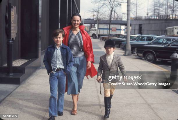 Swiss-born socialite Gloria Vanderbilt and her two sons, Carter Vanderbilt Cooper and Anderson Cooper, walk along a sidewalk in New York, New York,...