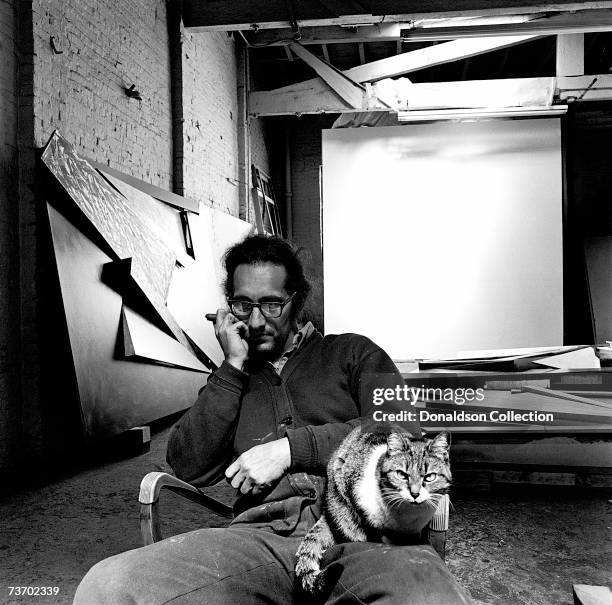 Artist Frank Stella poses with his cat at his studio in 1975 in New York.