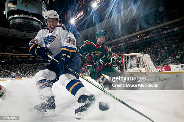 Ville Nieminen of the St. Louis Blues skates for the puck against Wyatt Smith of the Minnesota Wild during the game at Xcel Energy Center on March...
