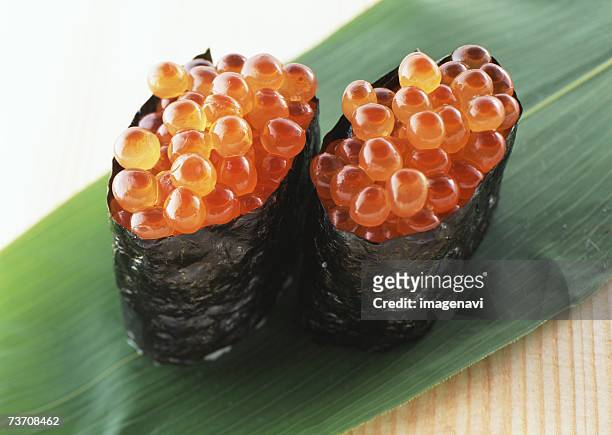 salmon roe sushi on bamboo leaf - gunkanmaki stock-fotos und bilder