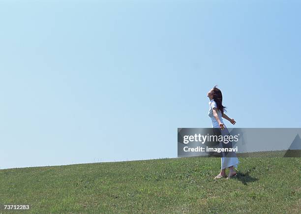 woman walking in field - blue skirt stockfoto's en -beelden