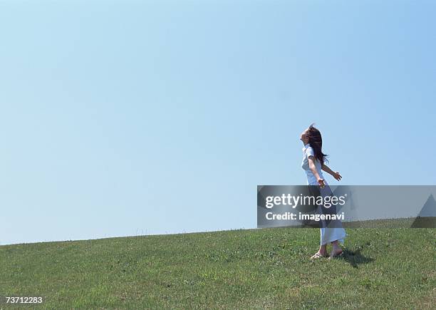 woman walking in field - blue skirt stock pictures, royalty-free photos & images