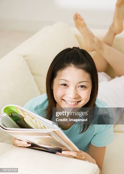 woman relaxed on sofa - woman smiling facing down stock pictures, royalty-free photos & images