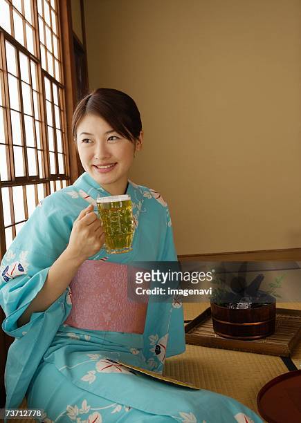 woman dressed yukata and beer - beer mat stockfoto's en -beelden