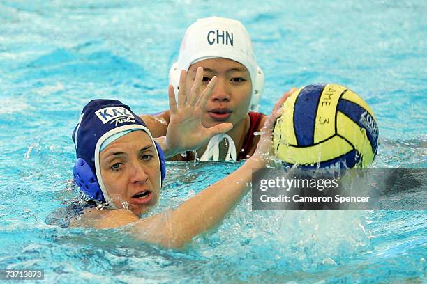 Tatyana Gubina of Kazakhstan gets away from Gao Ao of China in the Women's Final Round 13th-14th place Water Polo match between China and Kazakhstan...