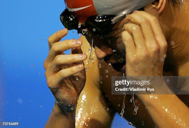 Peng Wu of China washes his face in the Men's 100m Backstroke semi-final during the XII FINA World Championships at the Rod Laver Arena on March 27,...