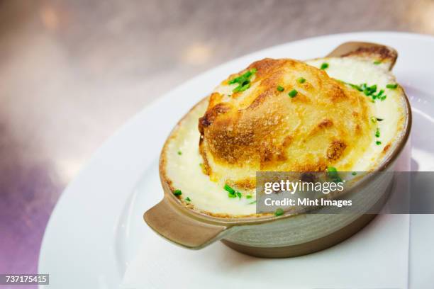 close up of a cheese souffle in a ramekin. - souffle stock pictures, royalty-free photos & images