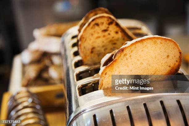 close up of slices of bread in a stainless steel toaster. - toaster fotografías e imágenes de stock