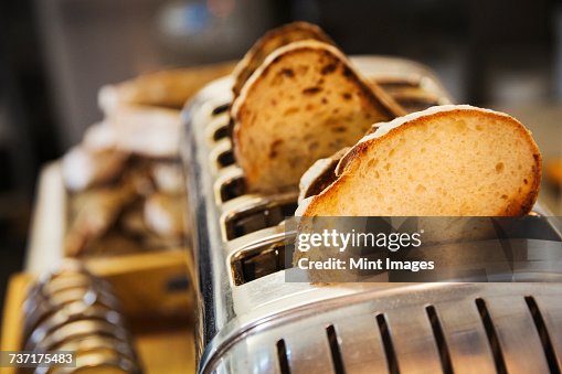 Close up of slices of bread in a stainless steel toaster. Close up of slices of bread in a stainless steel toaster.