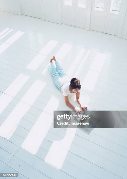 woman lying on floor with laptop - mit dem gesicht nach unten stock-fotos und bilder