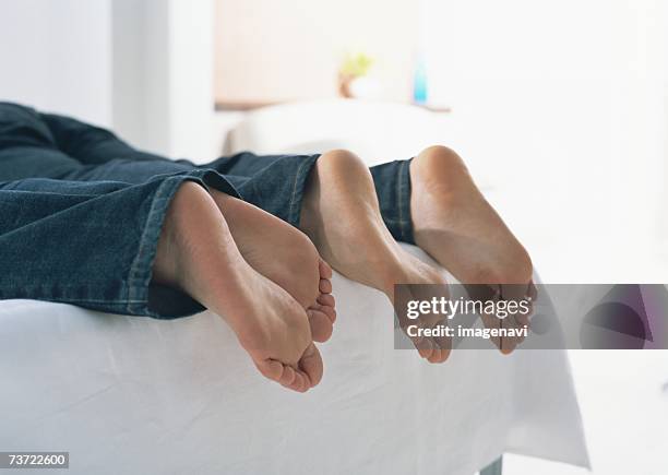 couples barefoot - woman lying on stomach with feet up fotografías e imágenes de stock