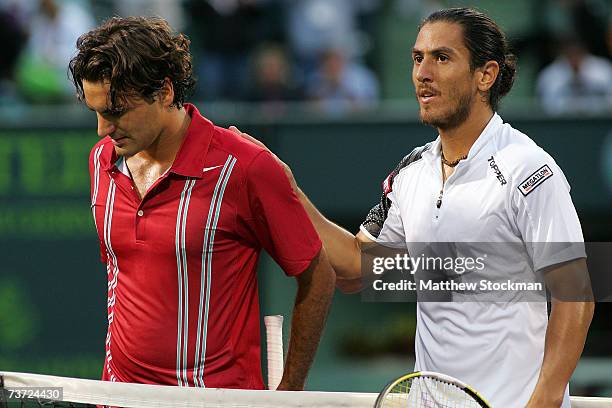 Guillermo Canas of Argentina pats Roger Federer of Switzerland on his back after Canas defeated Federer during day seven at the 2007 Sony Ericsson...