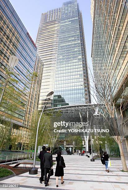 Visitors stroll along the inner court of the new development of office buildings and a shopping mall area "Tokyo Midtown", built at the former...