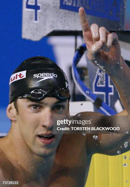 Michael Phelps of the US raises his hand after the men's 200m butterfly final, 28 March 2007 at the 12th FINA World Swimming Championships in...