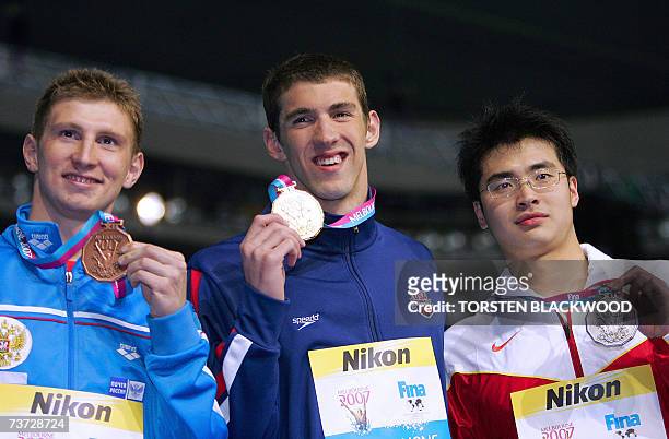 Gold medal winner Michael Phelps of the US, accompanied by silver medalist Wu Peng of China and bronze medalist Nikolay Skvortsov of Russia pose for...