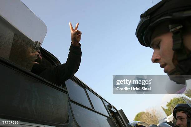 Man gestures from a van window as Israeli settlers are evacuated after they arrived to rebuild the Homesh settlement, which was evacuated in the...
